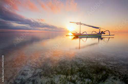 Twilight Sunrise at Sanur Beach Bali with traditional balinese jukung