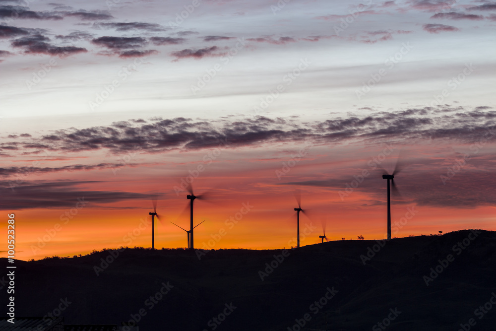 Landscape of dawn with windmills at horizon