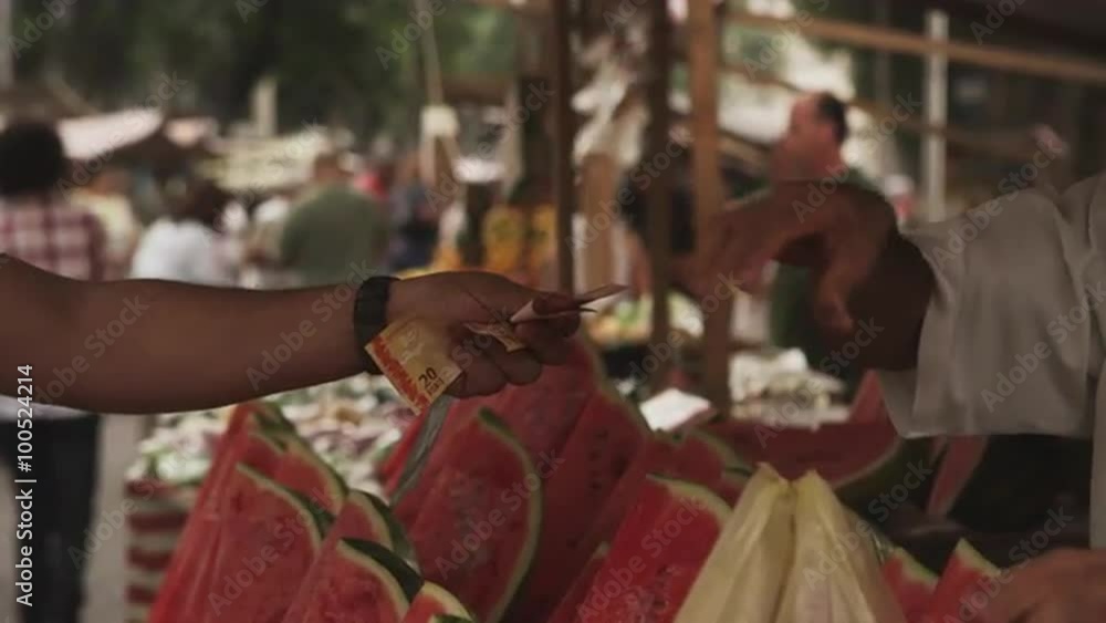 RIO DE JANEIRO, BRAZIL - JUNE 23: Buying watermelons at a market on June 23, 2013 in Rio, Brazil RIO DE JANEIRO, BRAZIL - JUNE 23: Buying watermelons at a market on June 23, 2013 in Rio, Brazil