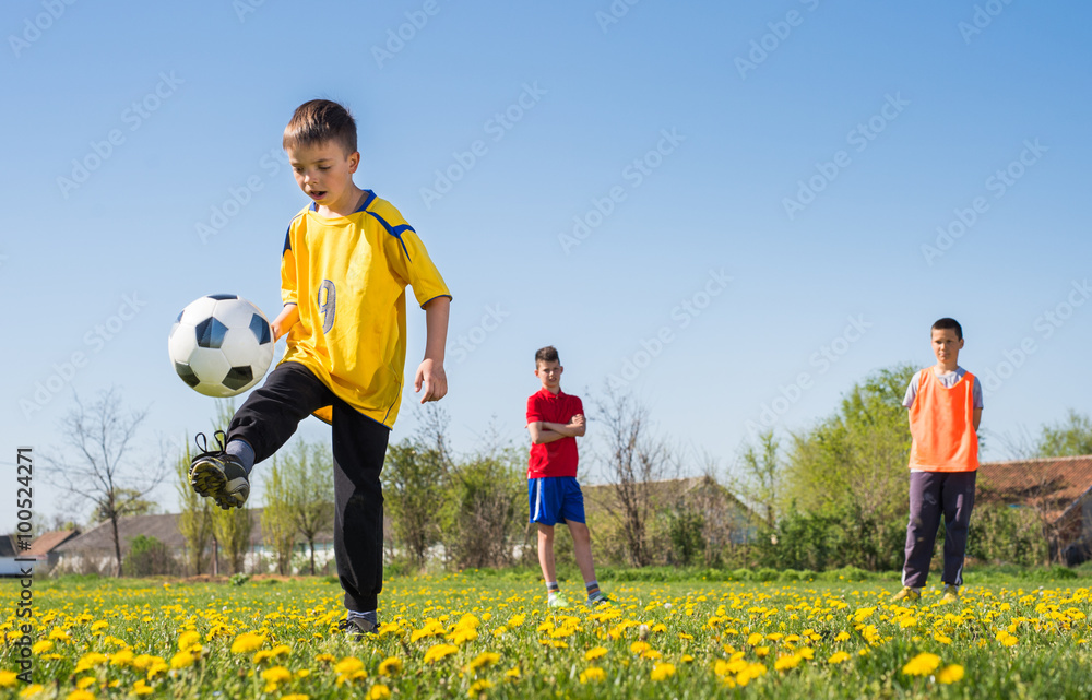 Boys kicking football