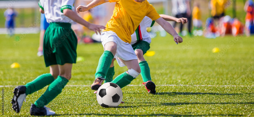 young boys of football academy playing football soccer game. Running players in colorful uniforms young boys of football academy playing football soccer game. Running players in colorful uniforms