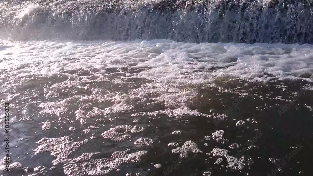 Pure fresh water boiling under waterfall. Clean and clear water in trout river with reflecting sunrays. Pure fresh water boiling under waterfall. Clean and clear water in trout river with reflecting sunrays.
