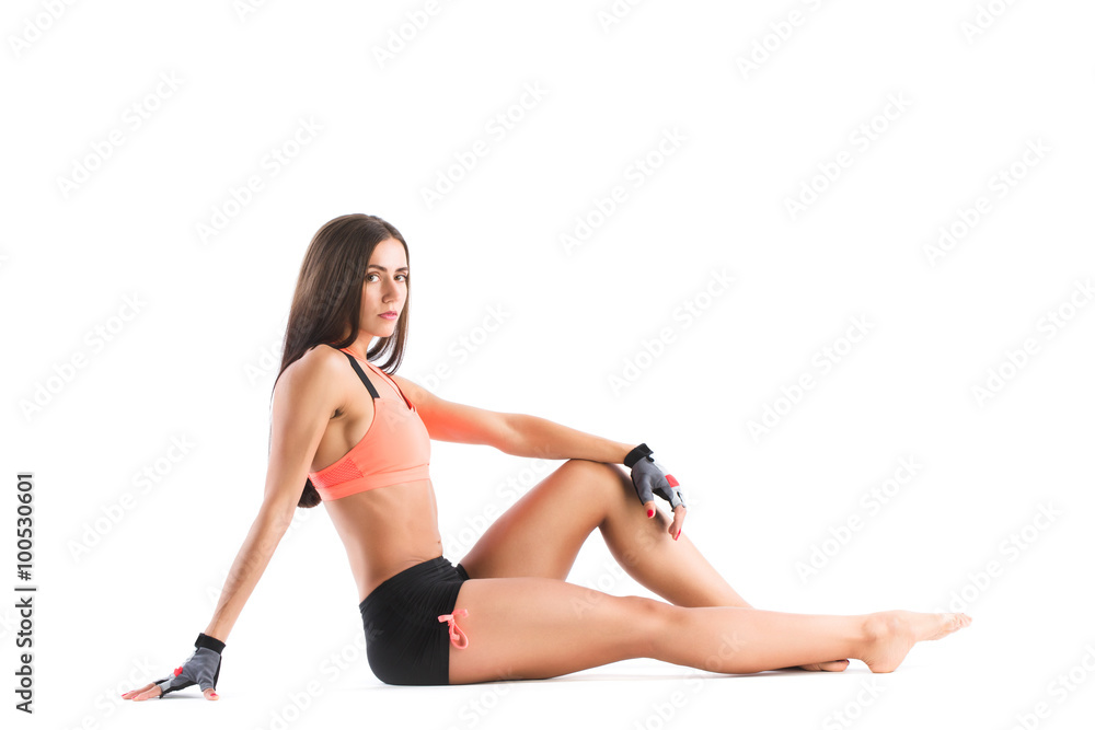 Athletic slim woman in sportswear sitting.