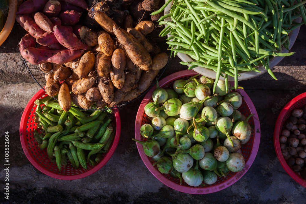 Fototapeta premium Baskets full of frsh vegetables under morning light at the street market, Vietnam.