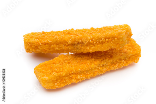 Frozen bread crumbed fish fingers on white.
