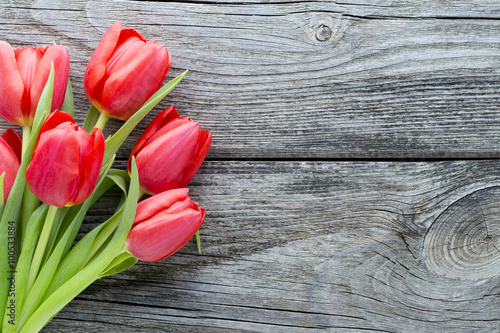 Fototapeta Naklejka Na Ścianę i Meble -  Red tulips on a wooden background.