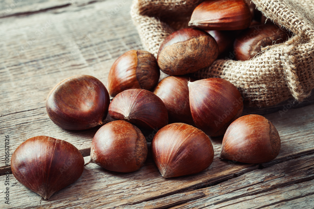Edible chestnuts in bag on rustic kitchen table. Edible chestnuts in bag on rustic kitchen table.