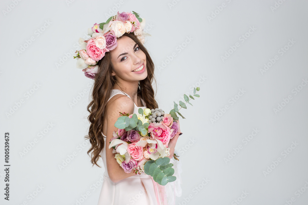 Beautiful happy bride in rose wreath holding bouquet of flowers Beautiful happy bride in rose wreath holding bouquet of flowers