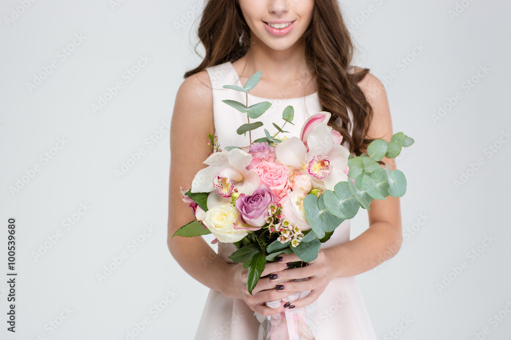 Beautiful bouquet of flowers holded by cheerful young woman