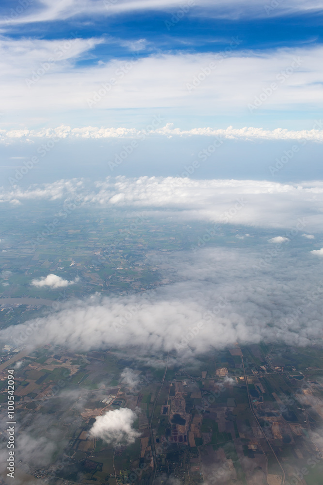 Aerial view on clouds and blue sky from airplane window