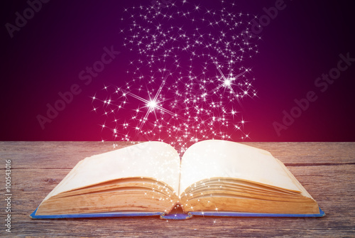 Abstract purple magic book on wooden background