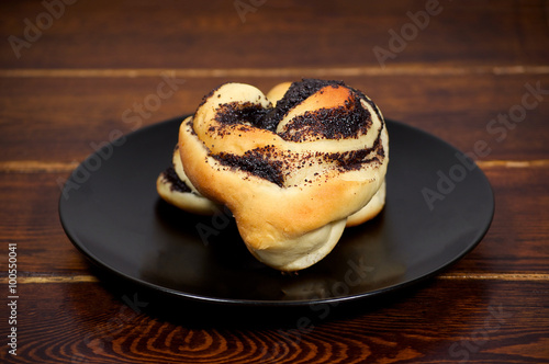 Baked bun with poppy on the plate