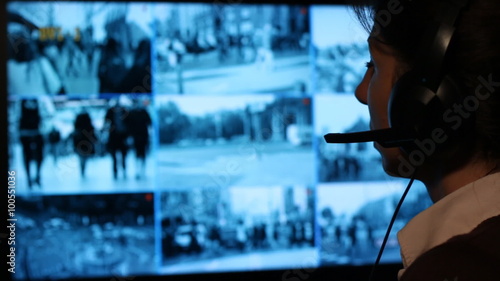 Security officer watching monitoring displays in control room. Security cameras