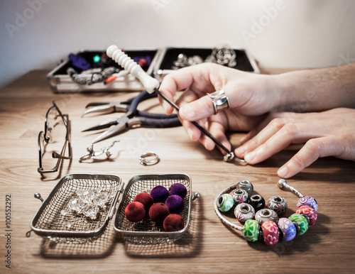 Hands of jewelry artist working at the table