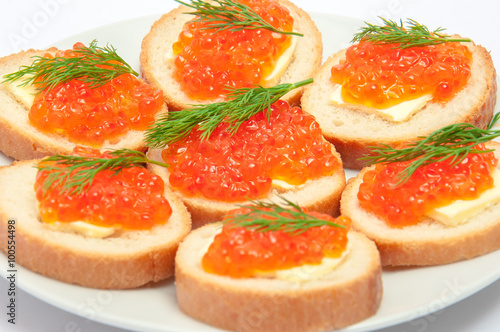 Bread with butter and red caviar in white plate. Sandwiches with