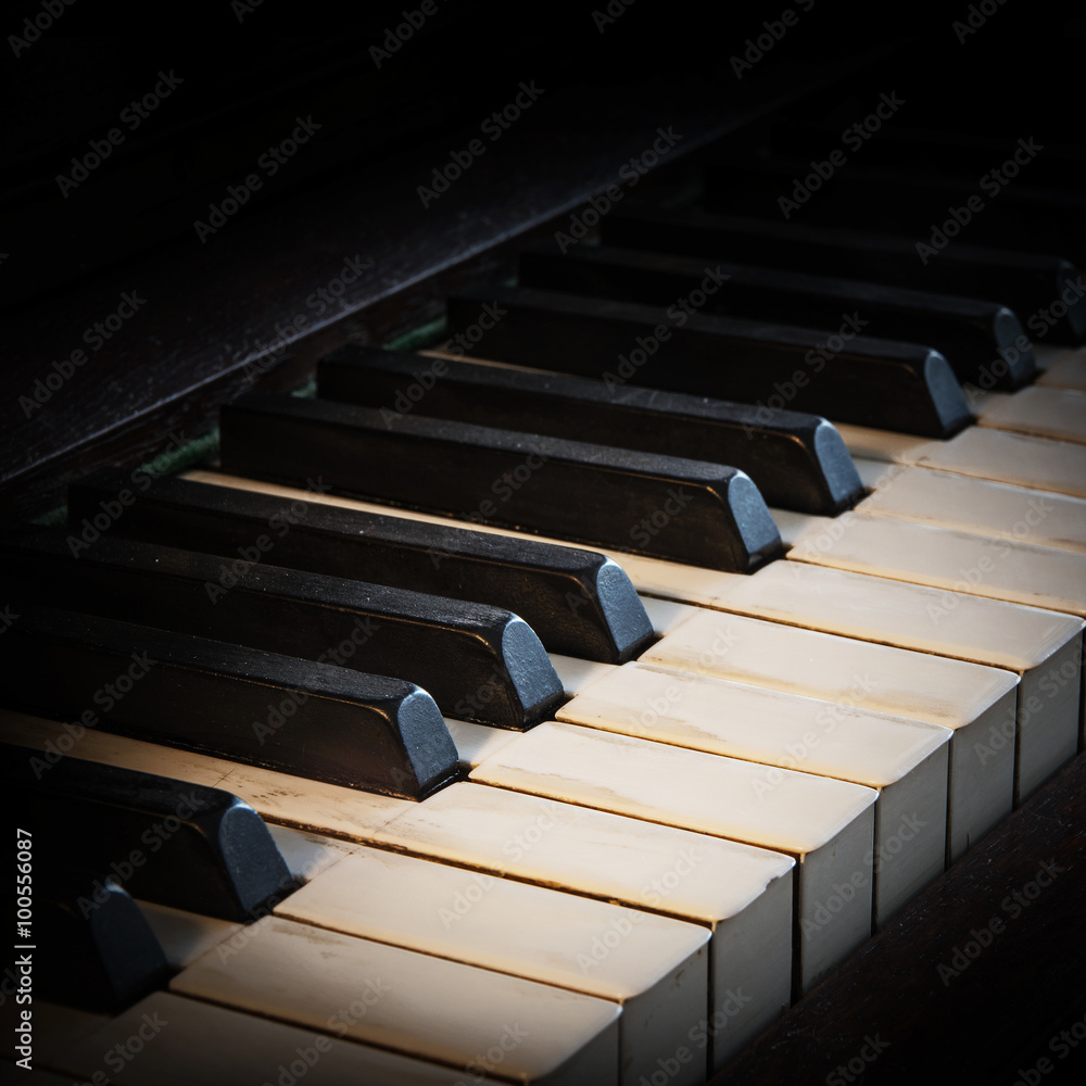 antique piano keyboard fading into a black background with copy
