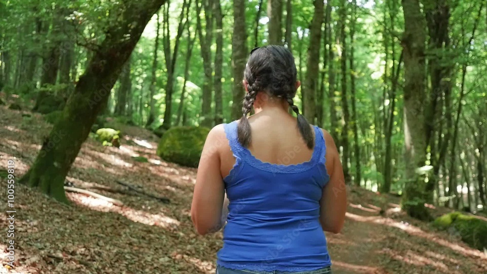 Woman walking in the forest. Shot in slow motion
Woman walking in the forest. Shot in slow motion