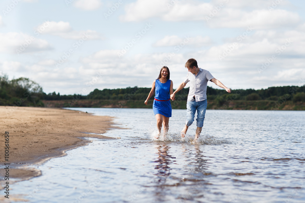 A young couple walks along the beach. A young couple walks along the beach.