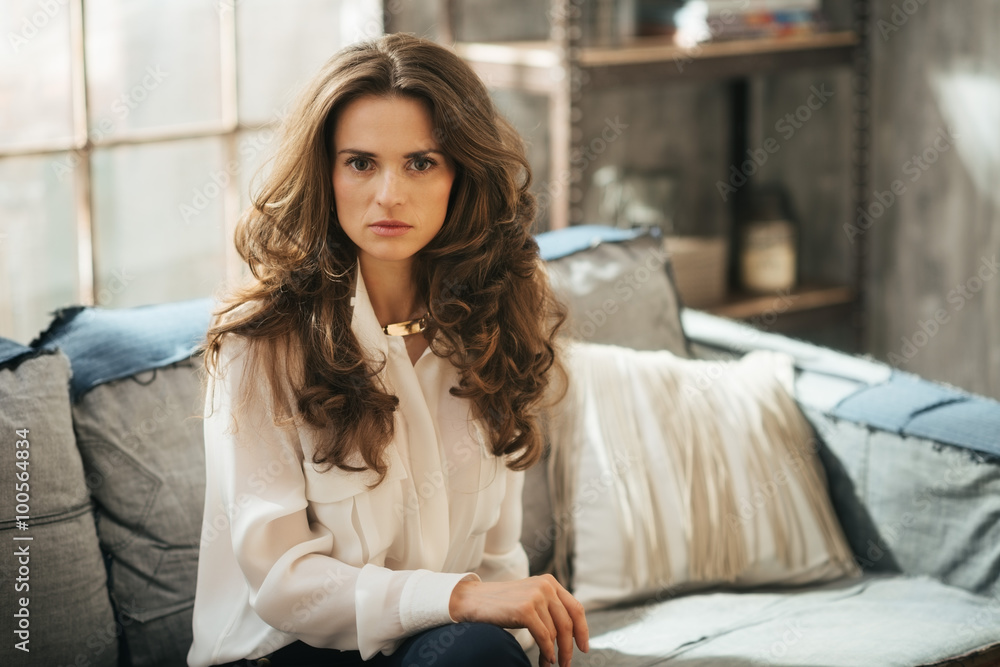 Half lenght portrait of elegant woman sitting on sofa in loft Half lenght portrait of elegant woman sitting on sofa in loft