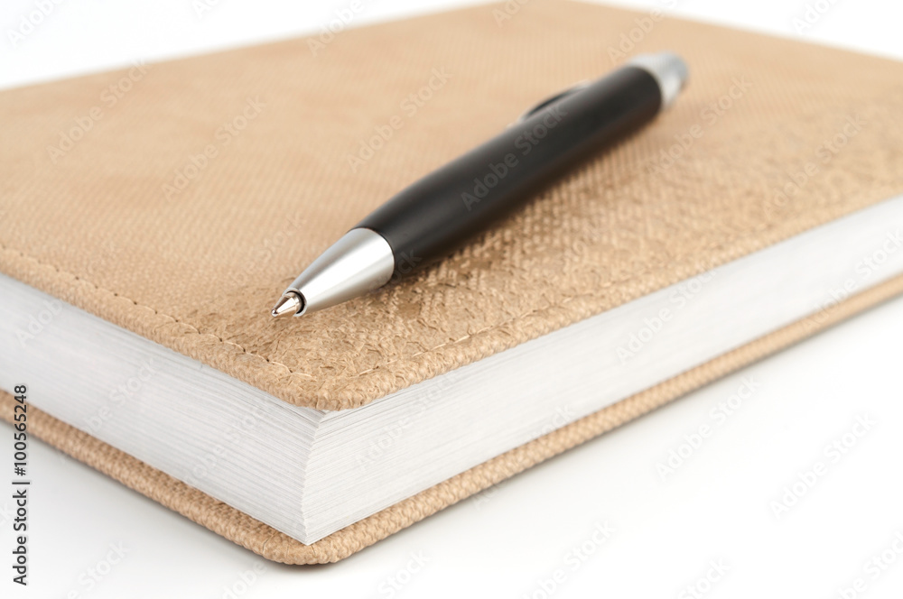 Black ballpoint pen on diary beige Black ballpoint pen on diary beige