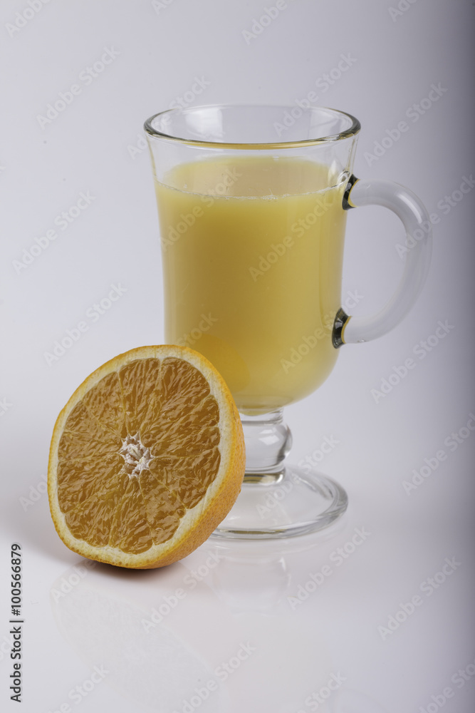 glass of juice and a sliced orange on white glass of juice and a sliced orange on white