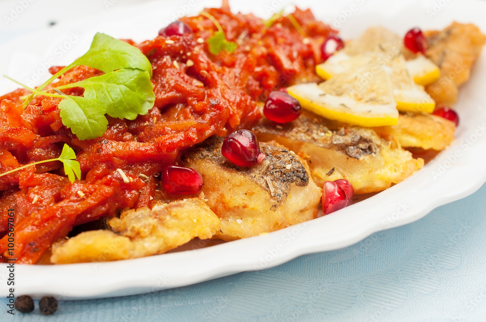 Pieces of fried fish with vegetable sauce. Pieces of fried fish with vegetable sauce.