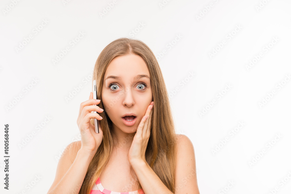 Surprised woman talking on the phone and touching her face Surprised woman talking on the phone and touching her face