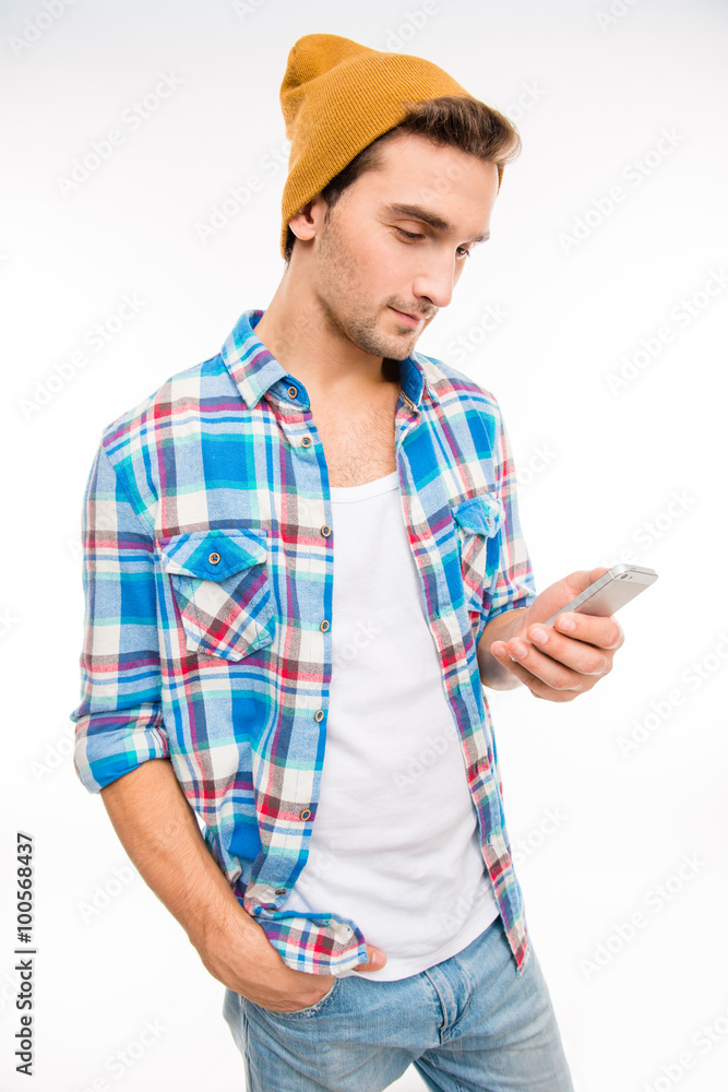 Young hipster with mobile phone holding hand in pocket Young hipster with mobile phone holding hand in pocket