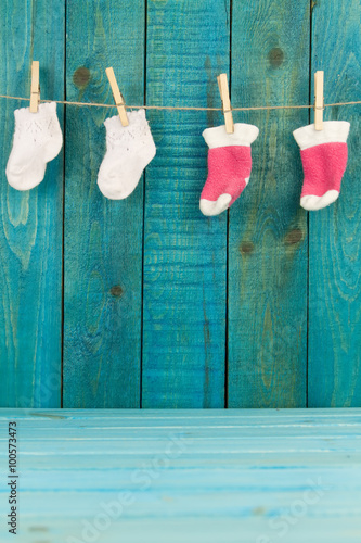 baby knitted woolen socks on primako on turquoise wooden background photo