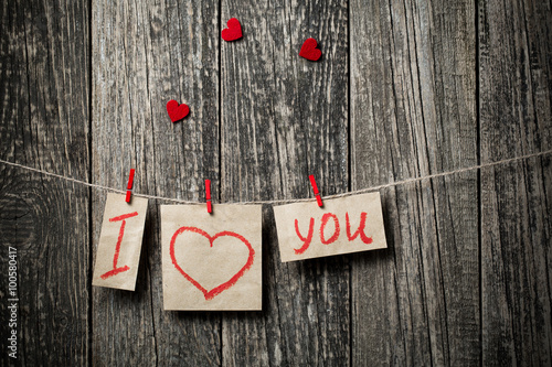 Foto Handwritten words I love you and hearts on wooden background.