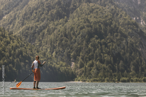 Woman Paddle boarding on a calm lake