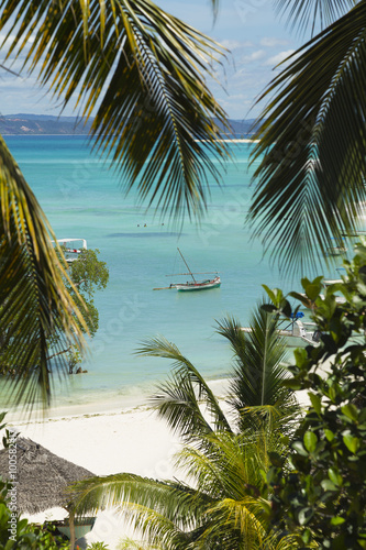 Boats on turquoise waters in a Malagasy tropical beach landscape in Nosy Iranja, Madagascar.