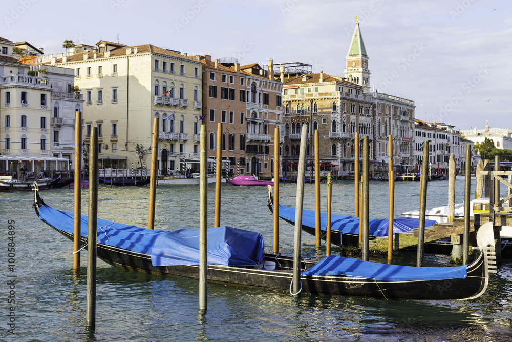 Naklejka premium Beautiful traditional black gondolas docked to the poles on the Grand Canal in Venice Italy