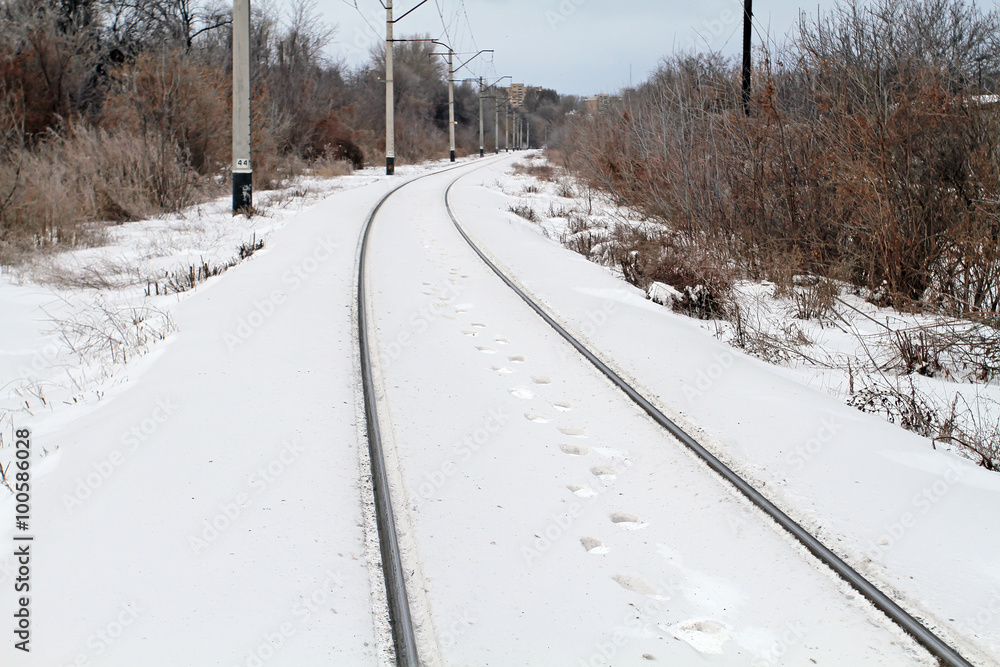 Obraz premium Traces of the person walking on the snowy railway. Next the whit