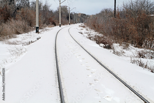 Traces of the person walking on the snowy railway. Next the whit