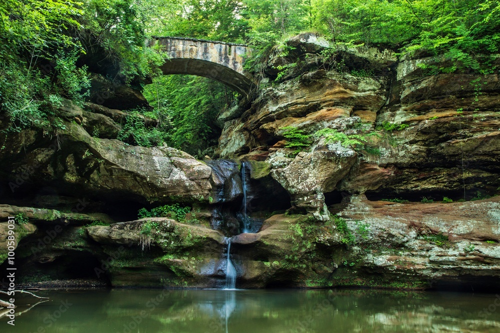 Enchanted Forest Waterfall. Stone bridge crosses over an enchanting