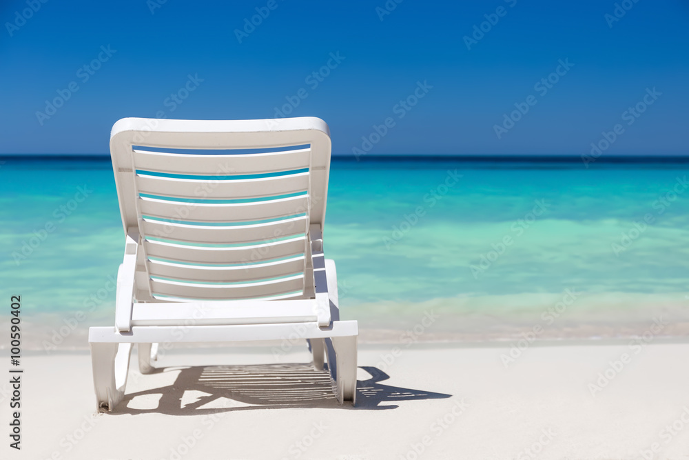 One sunbed on tropical calm beach with turquoise caribbean sea w