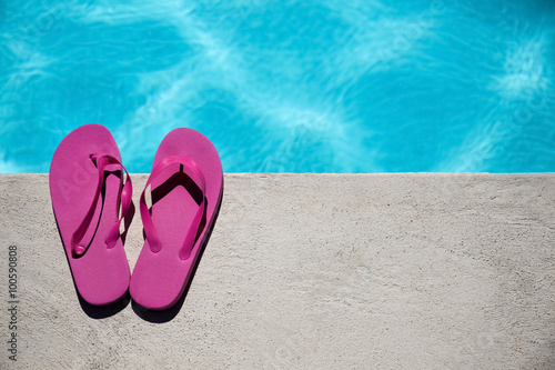 Pink slippers near swimming pool