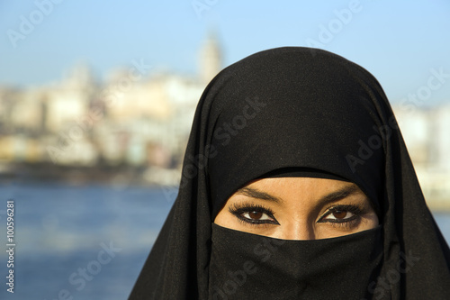 Woman dressed with black headscarf, chador on istanbul street, turkey photo
