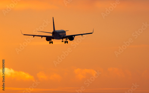 Airplane landing on sunset