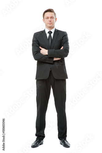 Young businessman in suit and tie keeping arms crossed