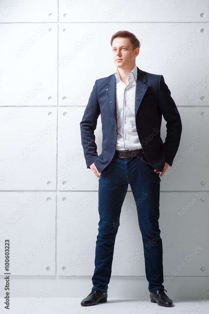 Young man looking away holding hands in pockets. Young man looking away holding hands in pockets.