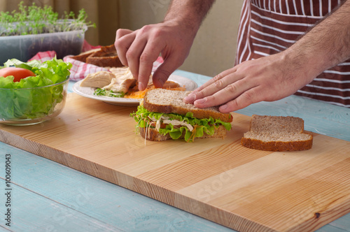 Man cooking big sandwich with chicken