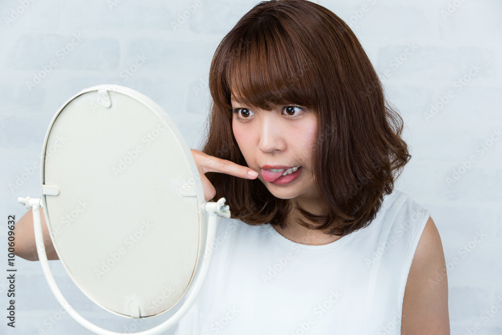 鏡・舌を気にする女性