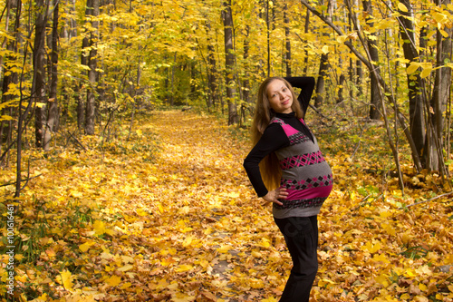 Walk in golden autumn forest expectant mother