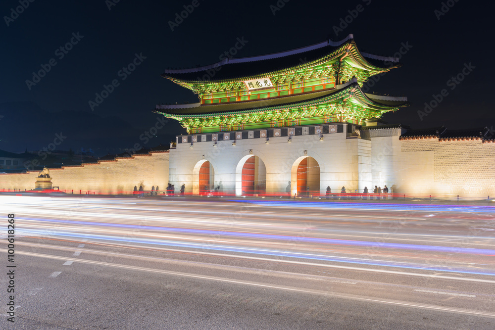 Fototapeta premium Traffic blurs past Gyeongbokgung palace at night in Seoul, South