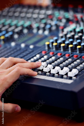 Hand adjusting audio mixer