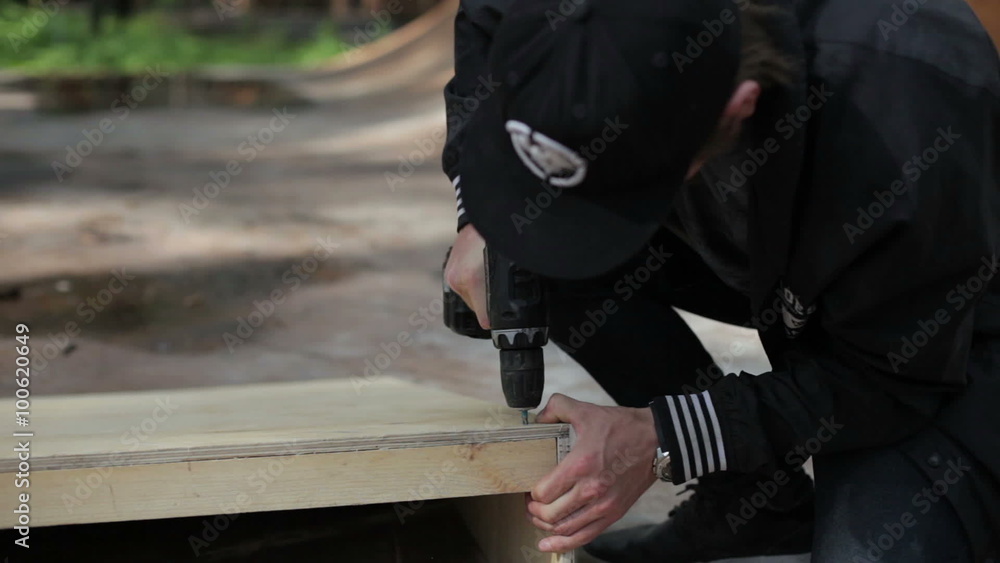 man drill a nail goods from wood in the skatepark man drill a nail goods from wood in the skatepark