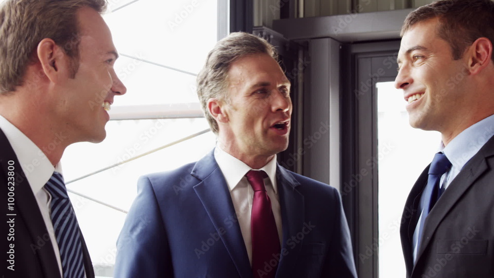 Businessmen talking together and shaking hands Businessmen talking together and shaking hands