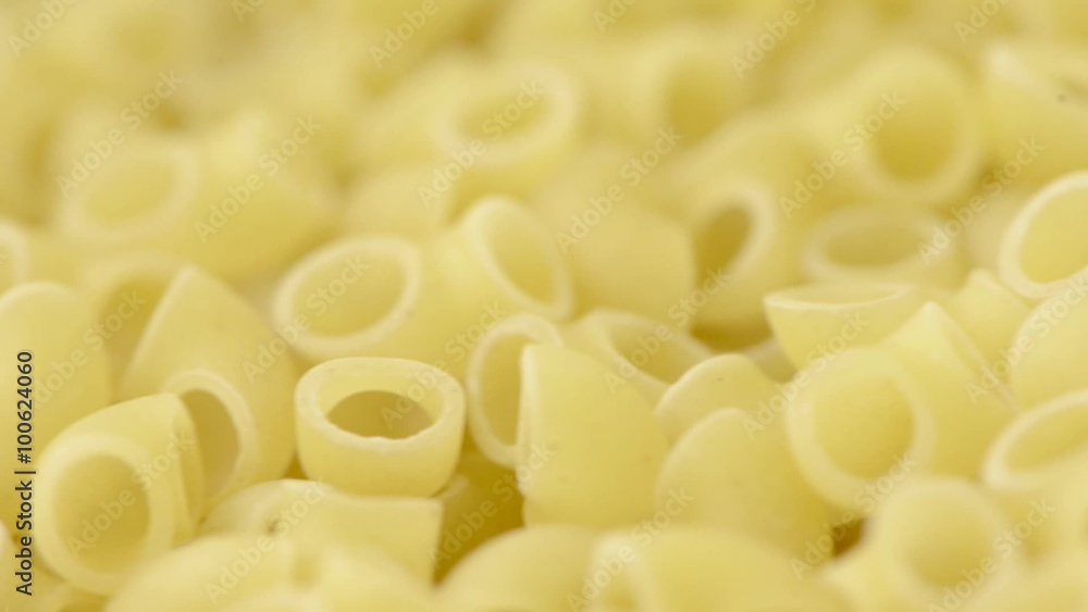 Macaroni pasta in close-up with slow panning sliding motion. Concept of italian food and cooking dinner. Macaroni pasta in close-up with slow panning sliding motion. Concept of italian food and cooking dinner.